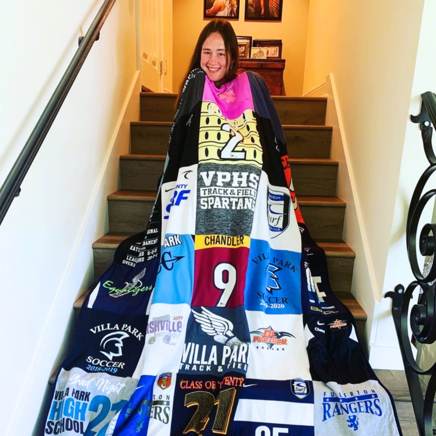 Grl holding her christmas gift - a memory blanket made of quilts.