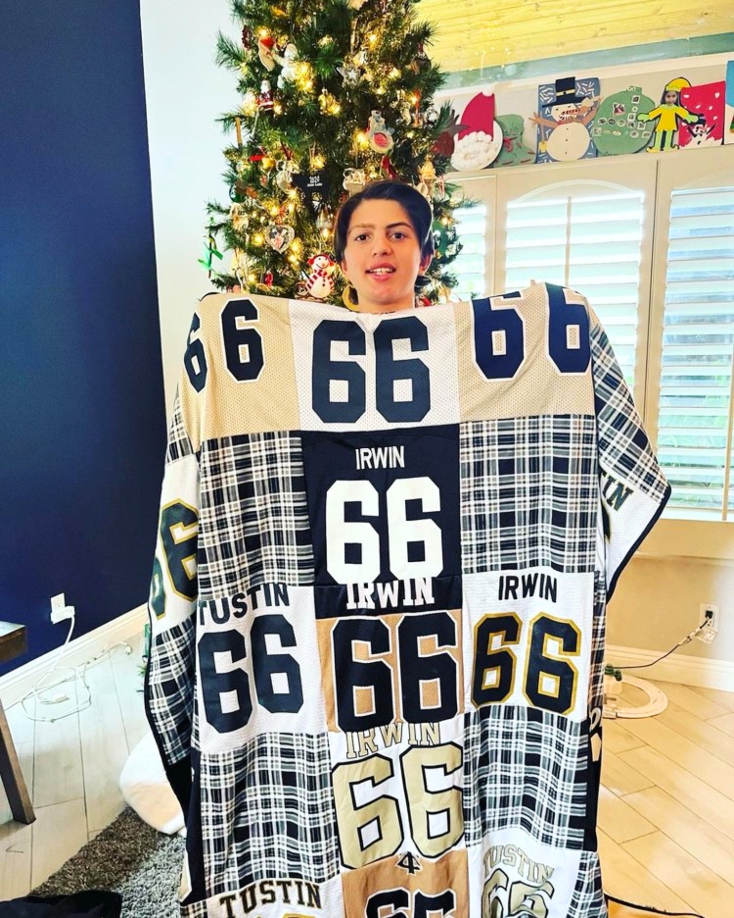 Boy holding quilt made of team jerseys